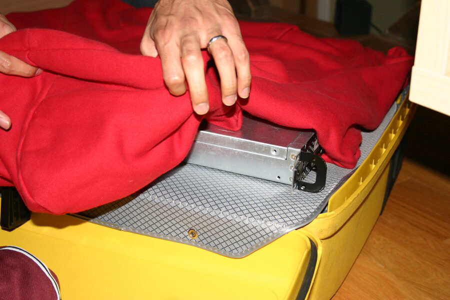 A rack server packed into a suitcase, padded with sweatshirts
